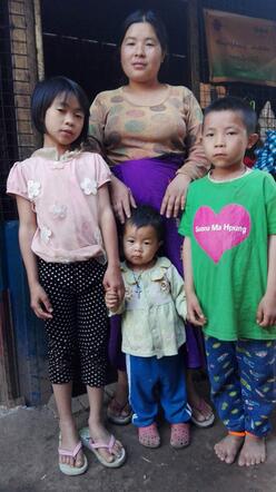 Mother and three children in front of their house