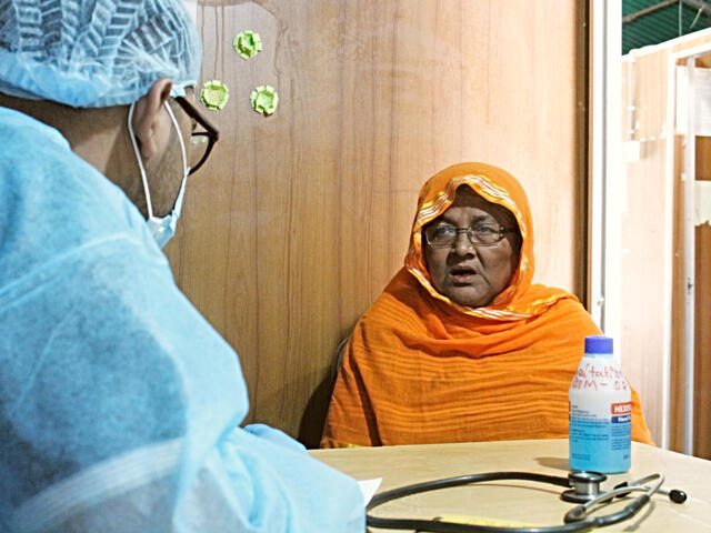 Dr. Muhaiminur speaks with Ambia, a 60-year-old refugee who came to the center with other health issues but had many questions about COVID-19.