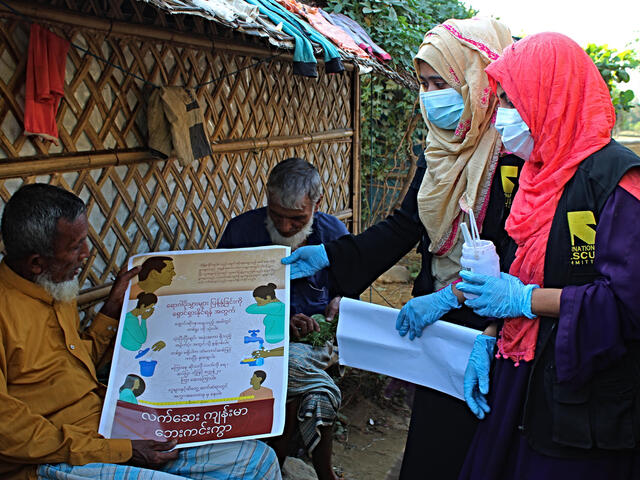 Umme Habiba, Rumana Afroz (wearing masks) and other IRC community health volunteers are trying to reach as many people as they can with information about how they can protect themselves from COVID-19.