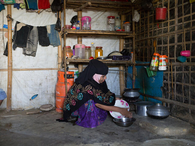 Photo of inside of Tahera's home, where you can see her washing a pot