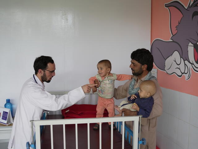 Shakeel and his twins getting a check-up from IRC healthworker Dr. Mujahid