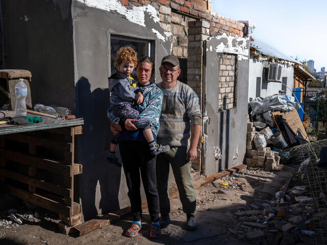 Ukrainian family standing outside their home