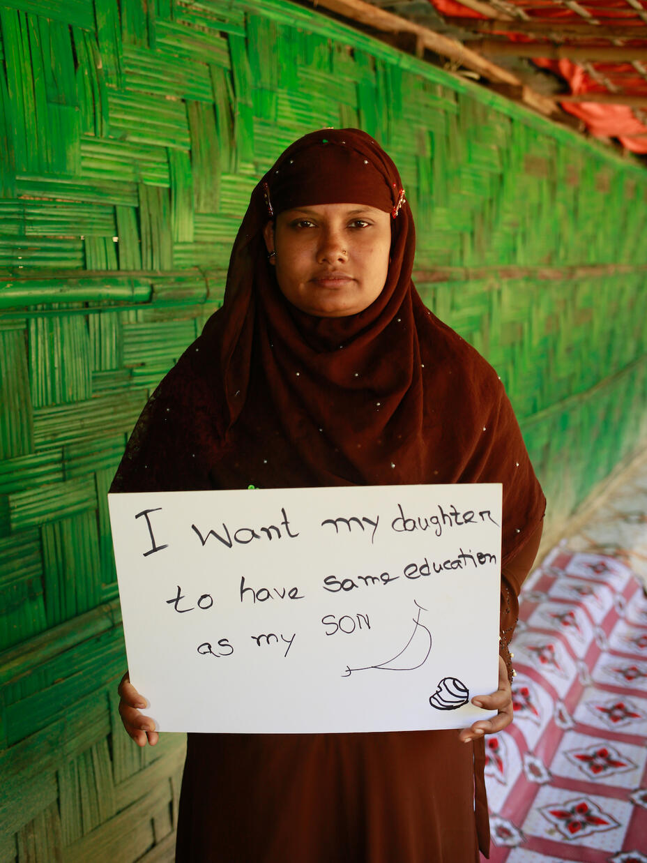 Rohingya woman Fatema, 32 years old, holds a sign that conveys her demand for women around the world in the camp where she lives - Ukhiya camp in Cox's Bazar.