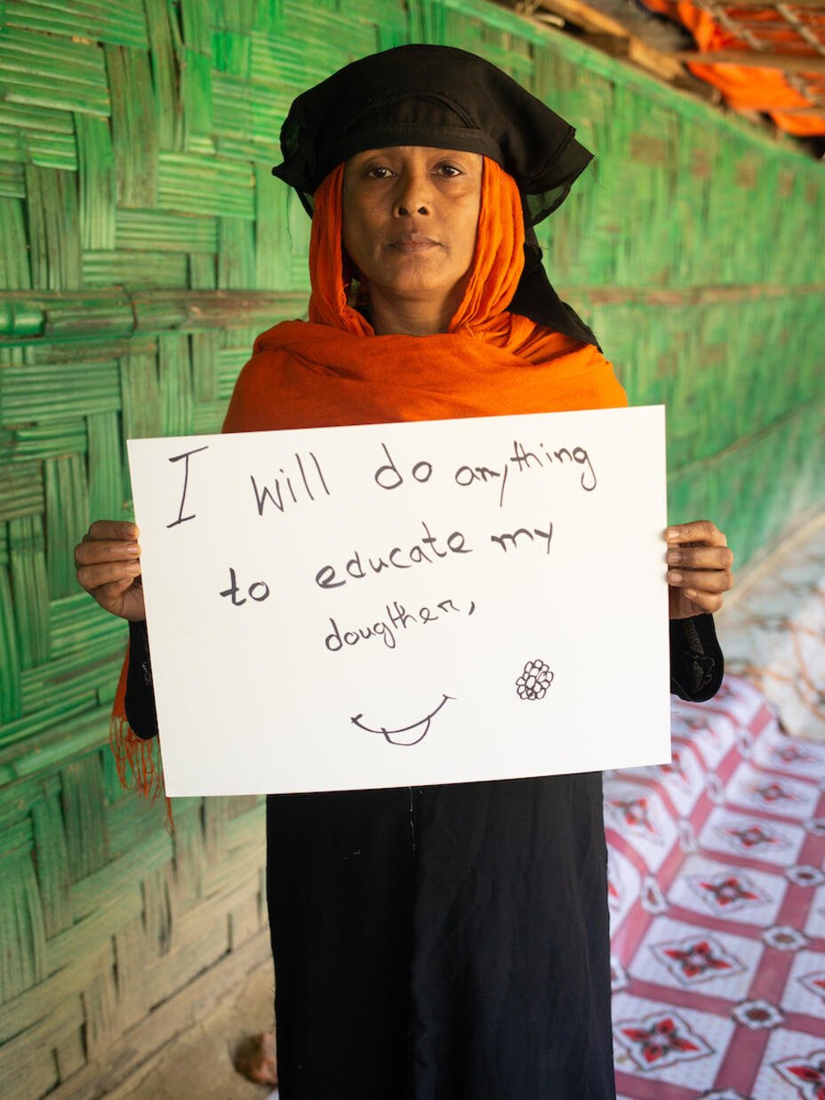 Rohingya woman Zorina, 50 years old, holds a sign that demonstrates her demand for women. Her daughter is 14 years old and called Rokiya Begum. 
