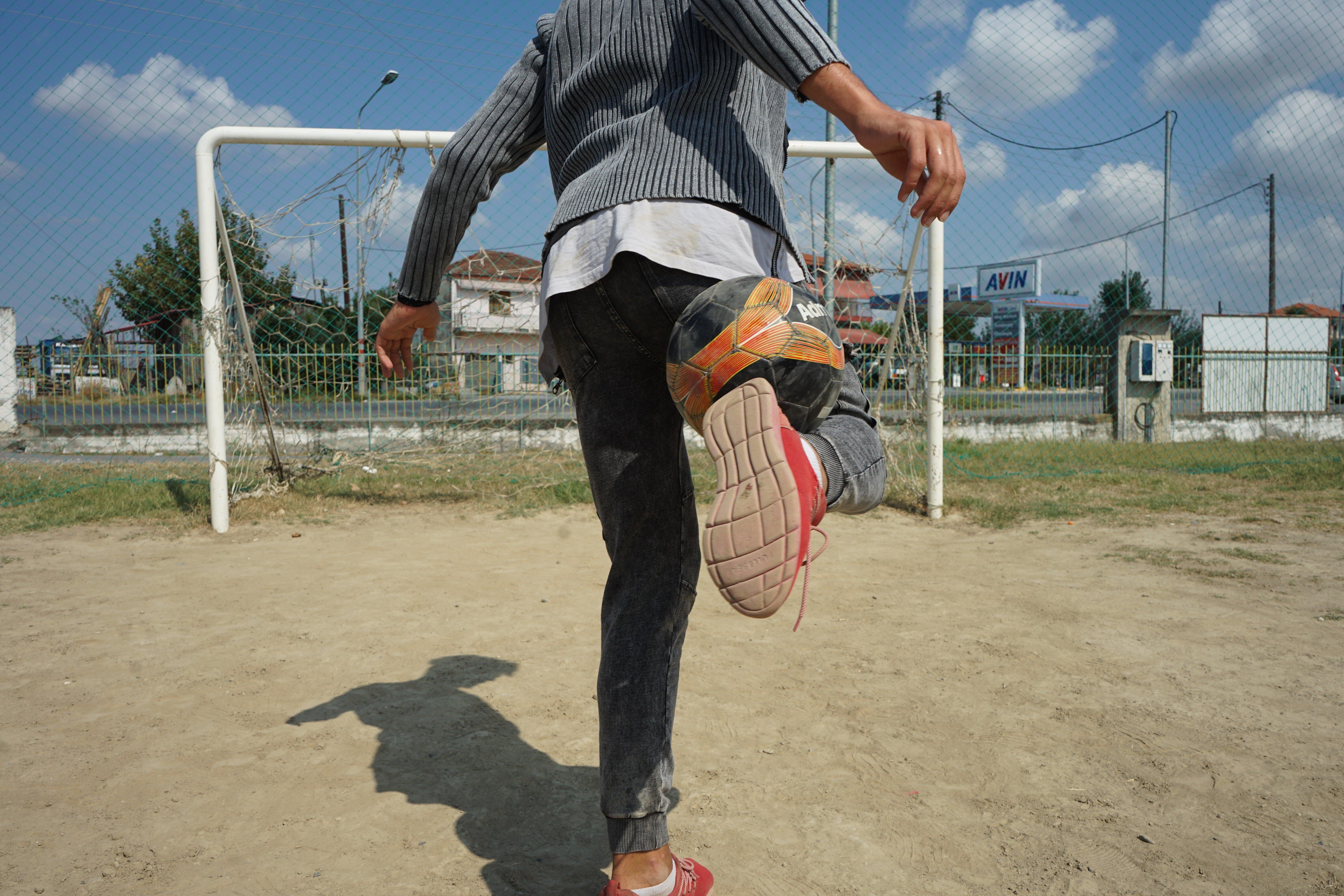 boy makes a trick with a football