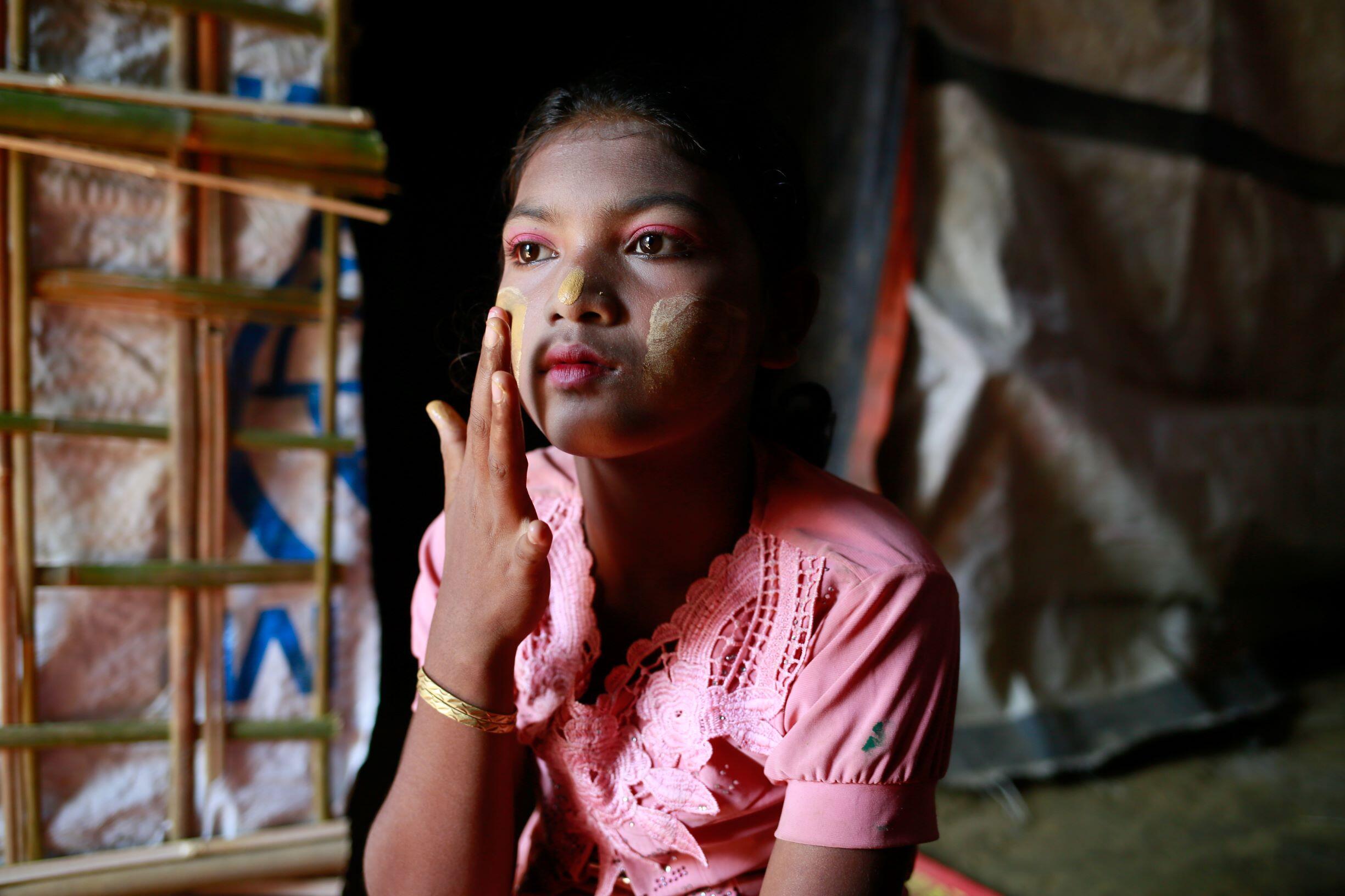 Hasina applying traditional make-up to her face