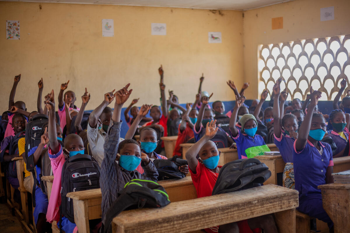 Shot of children in a public school raising hands