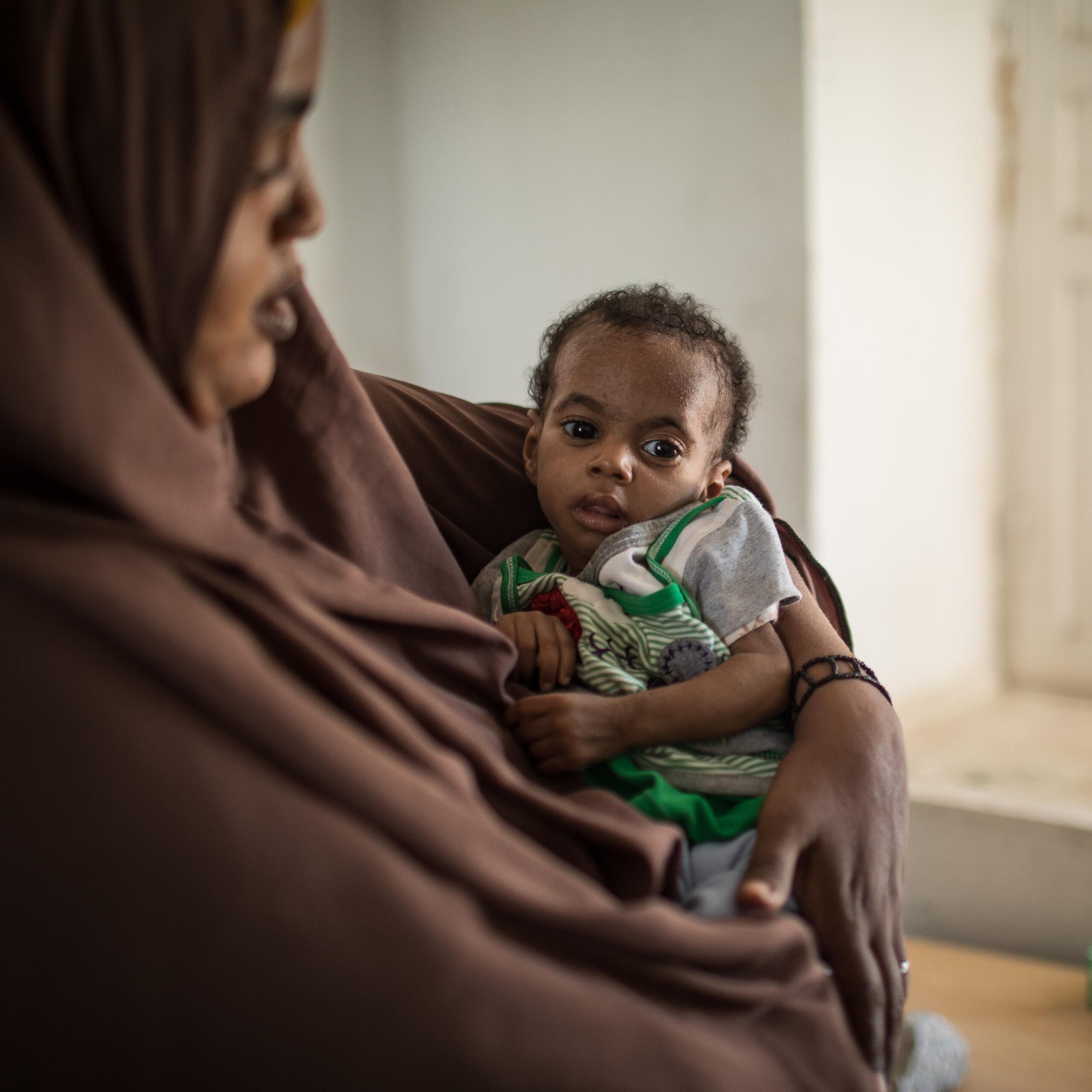 Somalian mother cradling her malnourished baby