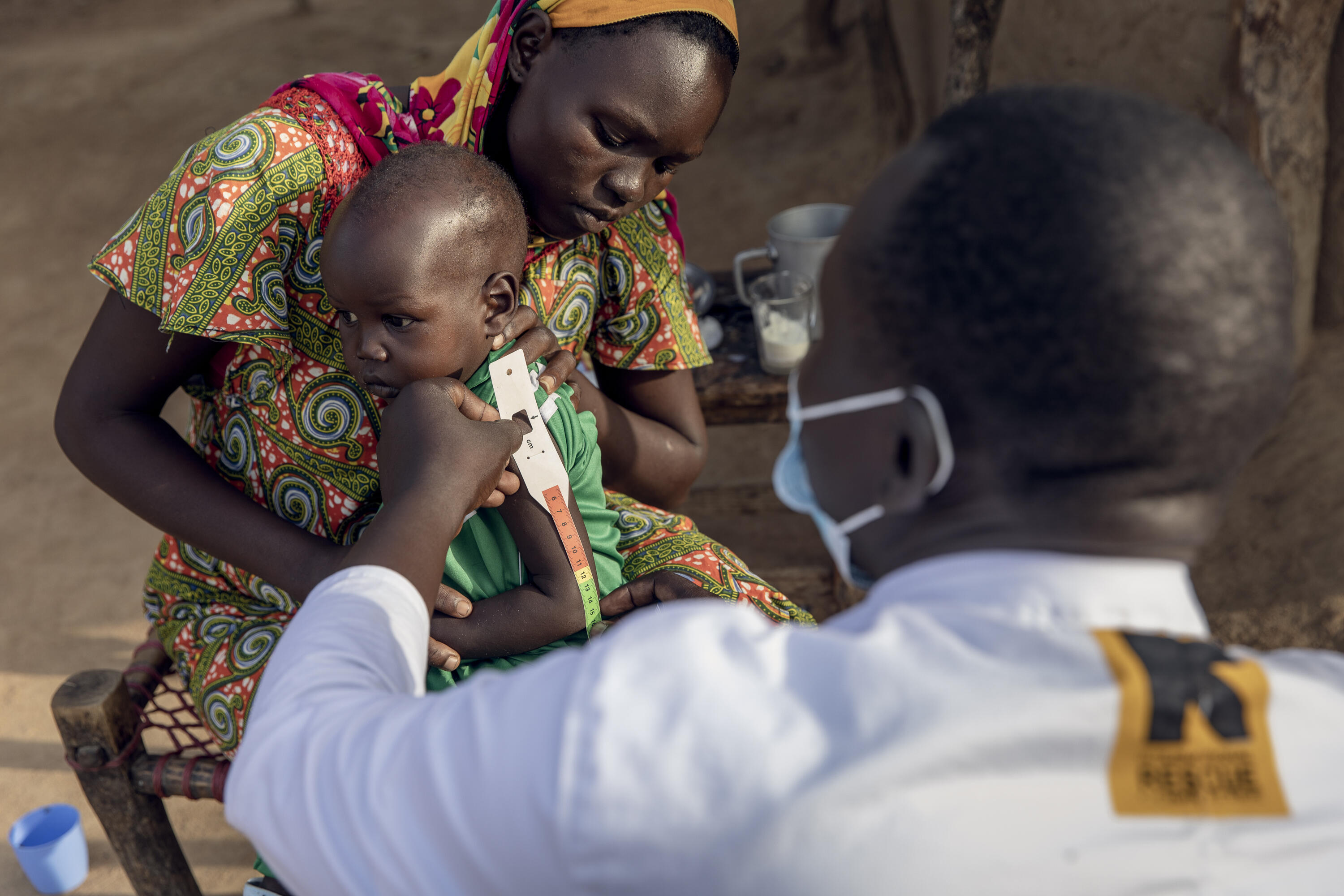 An IRC healthcare provider checks a baby for malnutrition in South Sudan