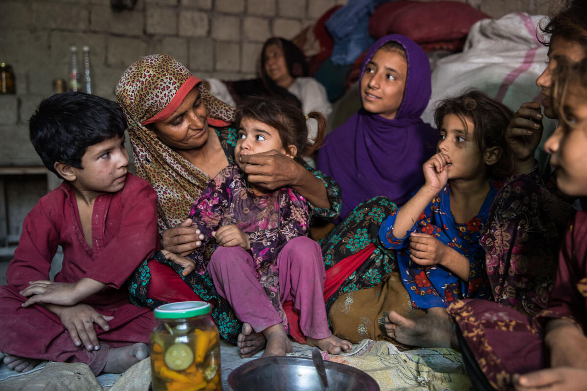 Sajida, her husband Rahmanullah Zarjan with their children on the floor of their home.