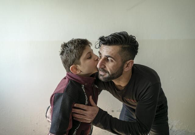 Abdessalam gives his father a kiss on the cheek