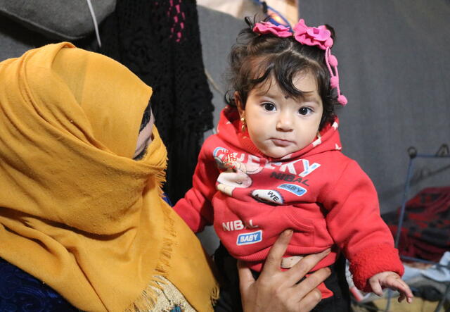 Um Tamer holds her baby daughter, Zainab, who was born in Areesha camp four months ago.