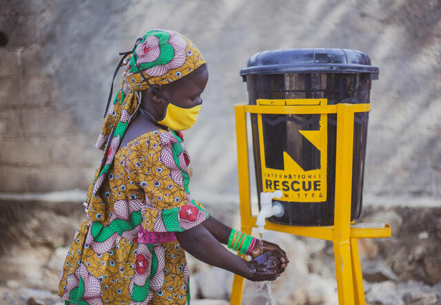 Anastasie washes her hands at a handwashing station set up by the IRC
