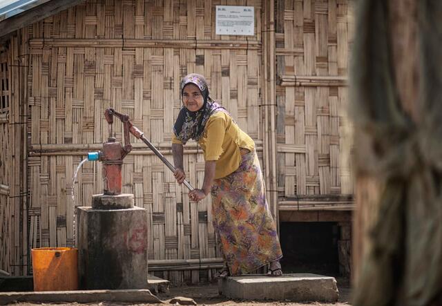 A women pumps water in Myanmar