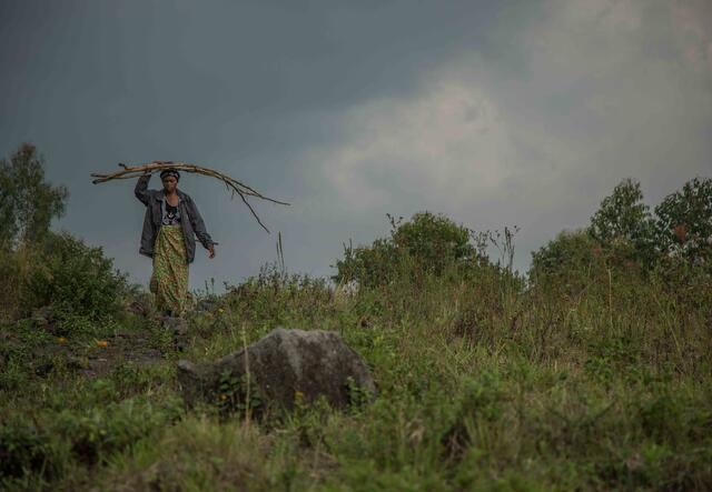 A woman walks through a field in Kong.