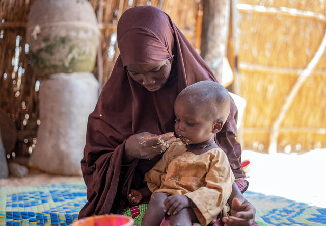 Eine Frau in Niger füttert ihr unterernährtes Kind