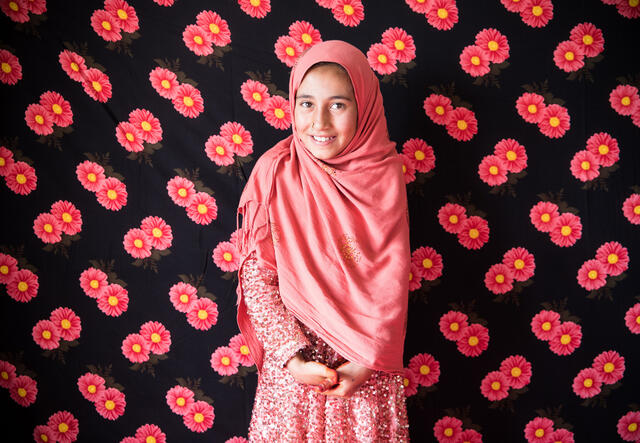 Lialoma standing in front of a flower-patterned background, smiling at the camera