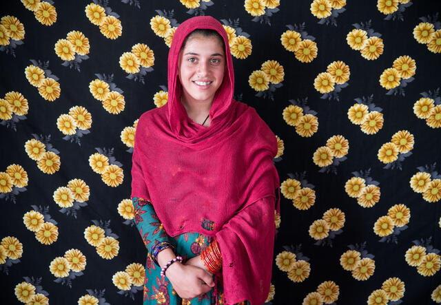 Marzia standing in front of a flower-patterned background, smiling at the camera