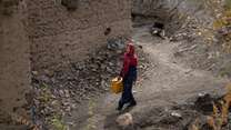 Rozama, 27, walks towards the river to collect water in Sabzaab Bala village, Bamiyan province, Afghanistan.