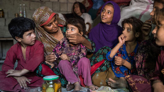 Sajida, her husband Rahmanullah Zarjan with their children on the floor of their home.